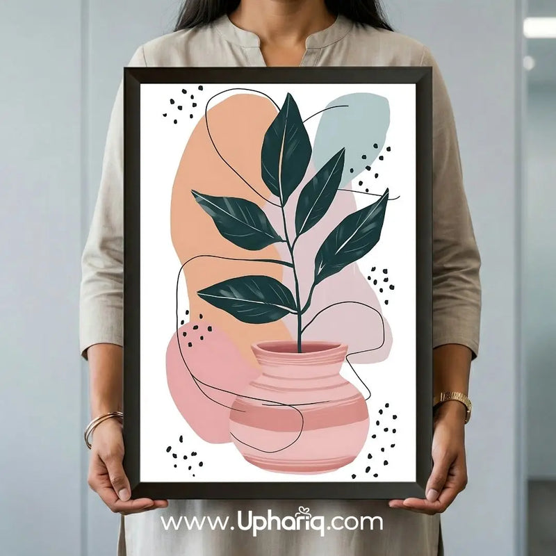 Person holding a large framed abstract botanical leaf vase wall art print to demonstrate the artwork's size and scale.